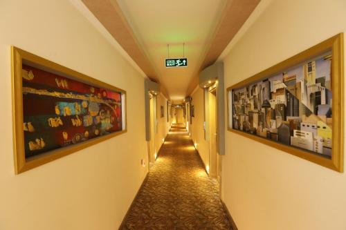 a hallway with two large pictures on the walls at Unluselek Hotel in Anamur
