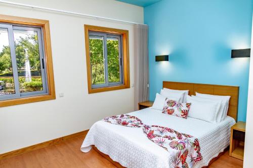 1 dormitorio con 1 cama y 2 ventanas en Boutique Mouras en Mondim de Basto