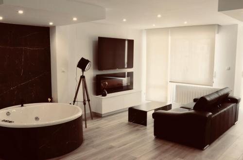 a bathroom with a tub and a chair and a couch at Black and White Suitte "Plaza" in Noja