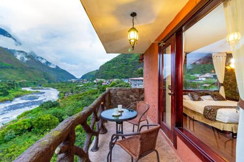 a room with a balcony with a bed and a table at Aldea Real Eco Friendly in Baños