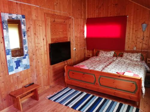 a bedroom with a bed and a flat screen tv at Tuuli Majutus in Tõrva