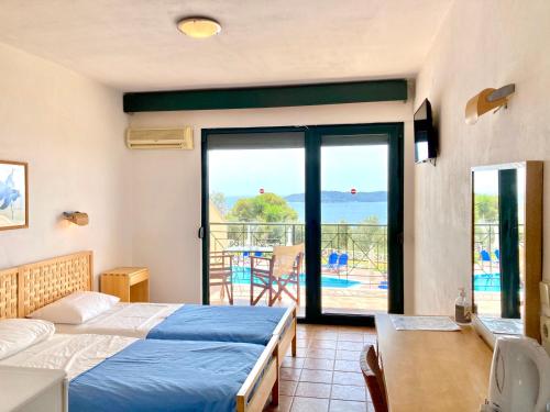 een slaapkamer met een bed en een balkon met uitzicht bij agnadi hotel in Achladies