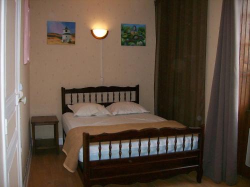 una camera da letto con un grande letto con cuscini bianchi di Gîte "L'helpe" dans grande maison quercynoise entre Sarlat Rocamadour a Gourdon en Quercy
