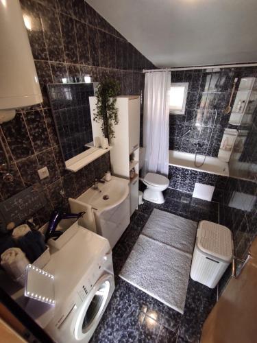 a bathroom with a sink and a toilet and a tub at Apartment Sky Central in Makarska