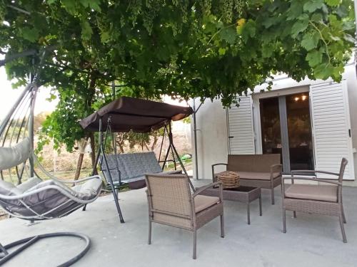 a group of chairs and an umbrella on a patio at Ktima Karamouzis in Petalidhion