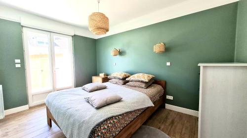 サンガットにあるÔ de Caps - à 50m de la plageの緑の壁のベッドルーム1室、ベッド1台(枕付)