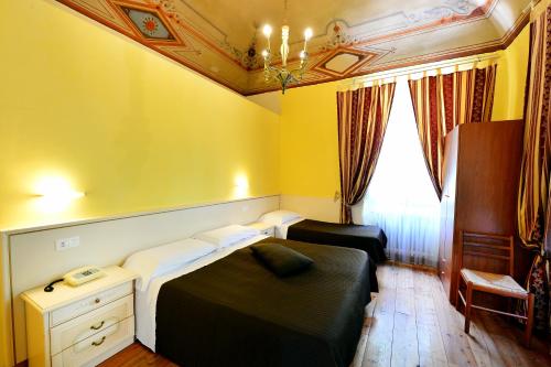 a small room with two beds and a window at Hotel Iris in Perugia