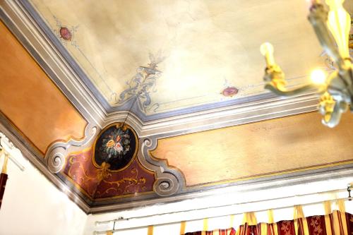 a room with a ceiling with a painting on it at Hotel Iris in Perugia