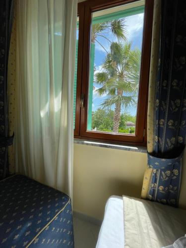a bedroom with a window with a palm tree at Villa Julia in Pompei