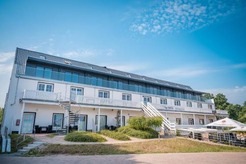 a large white building with stairs in front of it at Hotel Königslinie in Sassnitz