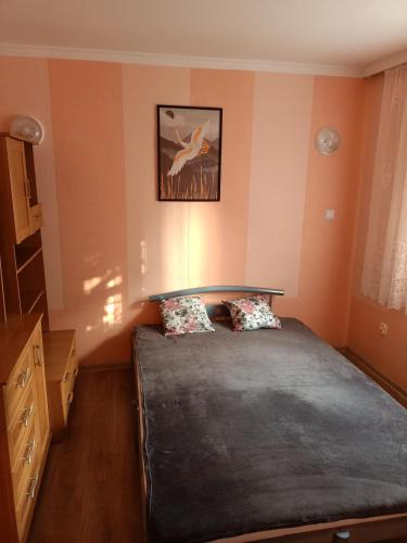 een slaapkamer met een bed en een foto aan de muur bij Mieszkanie w domu wielorodzinnym in Ryn