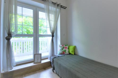 a bedroom with a bed and a large window at Pensjonat Stary Busko Zdrój in Busko-Zdrój