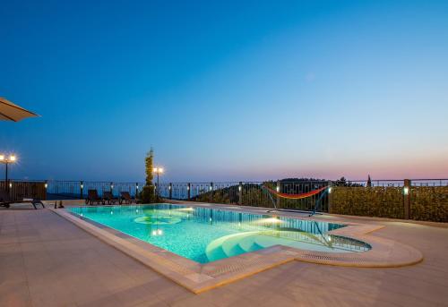 a swimming pool at night with the ocean in the background at VILLA MILENA in Kotor