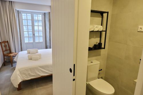 ein kleines Schlafzimmer mit einem Bett und einem WC in der Unterkunft Casas do Mercado - Casa Orion in Angra do Heroísmo