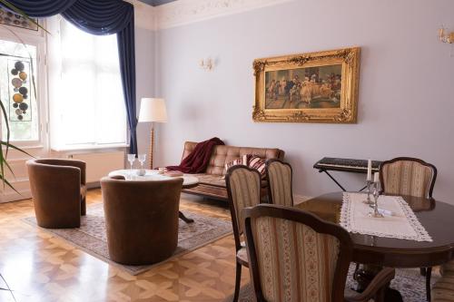 a living room with a couch and a table and chairs at Schlosshotel zum Markgrafen in Quedlinburg