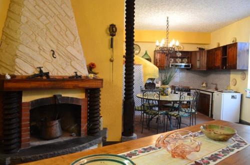 a kitchen and a living room with a fireplace at B&B Aria Dell' Etna in Zafferana Etnea
