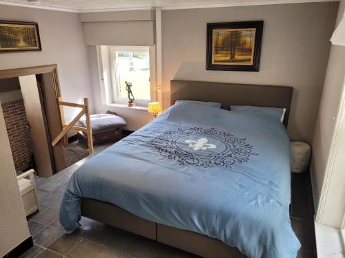 a bedroom with a blue bed with a flower on it at vakantiewoning hoeve 'd oude scheure in Kortemark