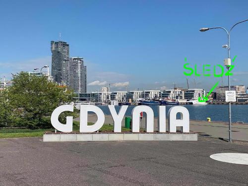 格地尼亞的住宿－Śledź Gdynia - YACHT PARK，城市里的一个大标志,上面写着gpxaho