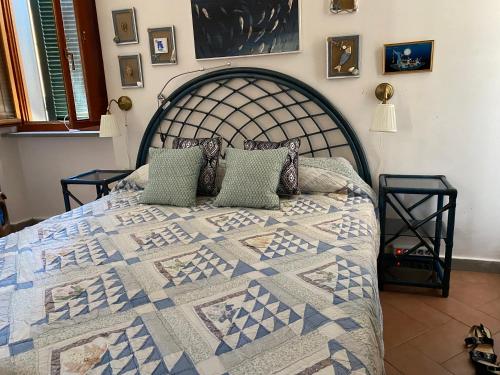 a bed with a quilt on it in a bedroom at STANZA INDIPENDENTE SUPER ARREDATA CENTRALE E LUMINOSISSIMA in Rio nellʼElba