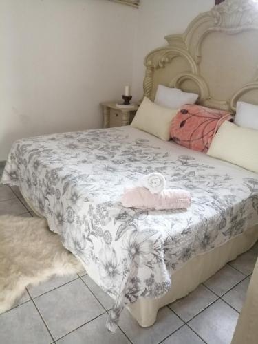 a bed with a white and pink blanket on it at Lytton Cresent B&B in Pinetown