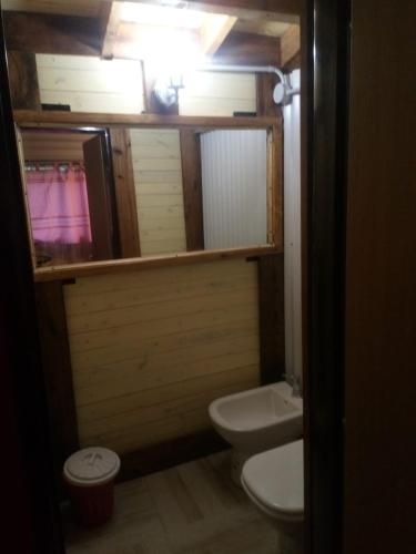a bathroom with a white toilet and a sink at Quelimbay in Puerto Madryn