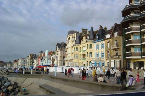 a group of people walking on a street with buildings at Wimereux 30m2 1 chambre et 1 canapé lit à 2 pas de la plage et du centre in Wimereux