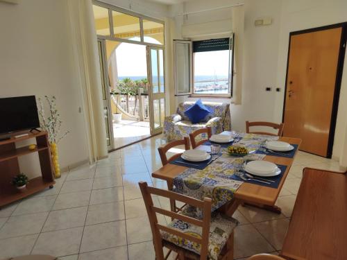 a dining room with a table and chairs and a television at LiMonello Marzamemi in Marzamemi