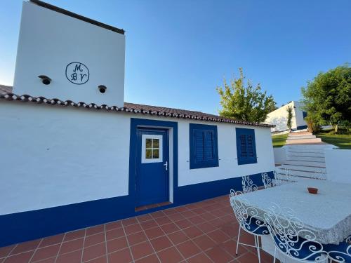 a house with a blue door and a table at Montes de Charme (AL 6288) in Avis