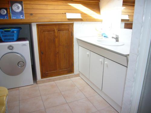 a bathroom with a sink and a washing machine at Les Tournesols in Saint-Andiol