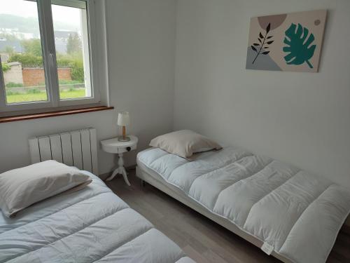 une chambre avec deux lits et une fenêtre dans l'établissement Le Nid Colas cour au sud vélos a dispo, à Fécamp