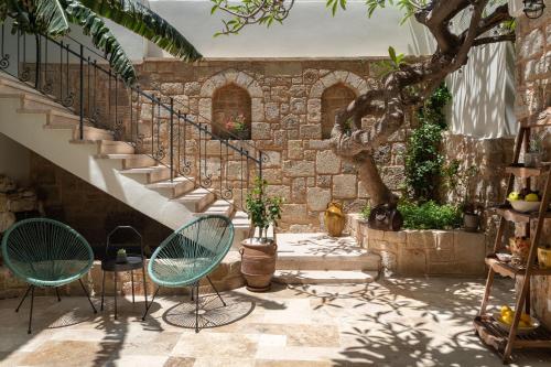 eine Terrasse mit 2 Stühlen und einer Treppe in der Unterkunft Casa Natura in Rhodos (Stadt)