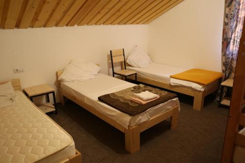 a room with two beds and a table and chairs at Пасторальний дім імені Владики Мілана in Bohdan
