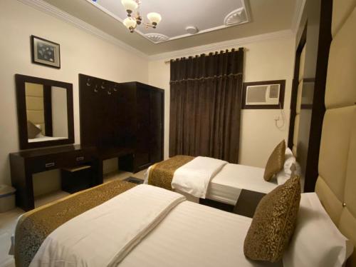 מיטה או מיטות בחדר ב-منازل الرؤية الفندقية