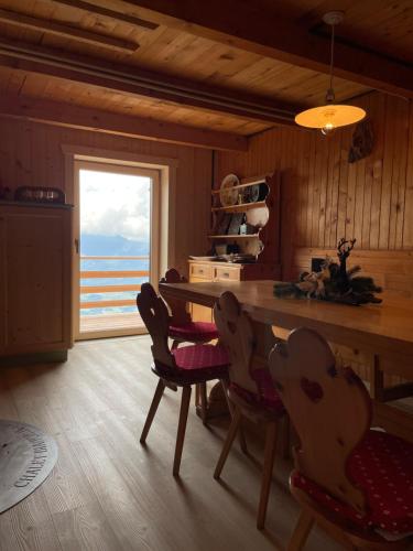 uma cozinha com mesa e cadeiras e uma janela em Chalet Biancaneve - Alpe Cermis Cavalese em Cavalese