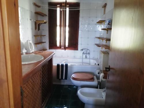 een badkamer met een bad, een toilet en een wastafel bij Casa Gianfranco Millepapaverirossi in Cese