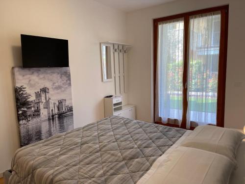 a bedroom with a bed and a large window at Appartamento Corallo in Sirmione