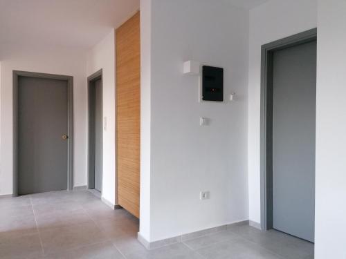 a hallway with three doors and a television on a wall at Endless Summer Pool Flat in Ixia