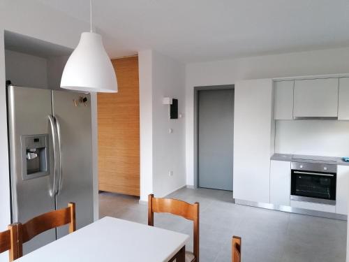 a kitchen with a white table and a refrigerator at Endless Summer Pool Flat in Ixia