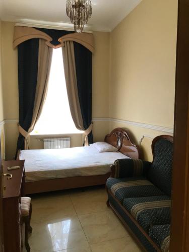 um quarto com uma cama, uma janela e um sofá em Beautiful apartment in the center of Vinnytsia em Vinnytsya