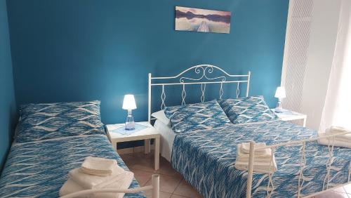 una camera con due letti e una parete blu di Le Colline di Paestum a Capaccio-Paestum