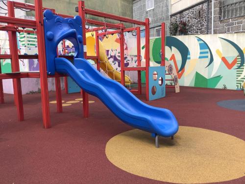 a playground with a blue slide in a room at Casa De Ferias Santos in Aguiar da Beira