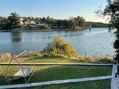 a swing set on the grass next to a river at Montes de Charme (AL 6288) in Avis