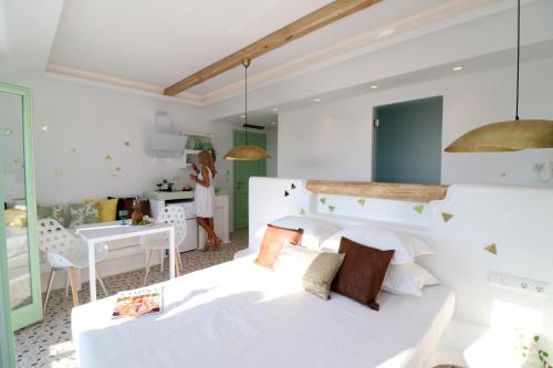 a bedroom with a white bed and a desk at Vino suites in Agia Anna Naxos