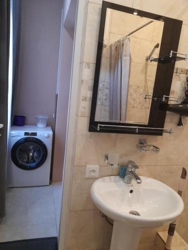 a bathroom with a sink and a washing machine at Lela Guest House in Mestia