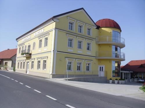 a yellow building on the side of a street at Gostilna in prenočišče KOCJAN in Bizeljsko
