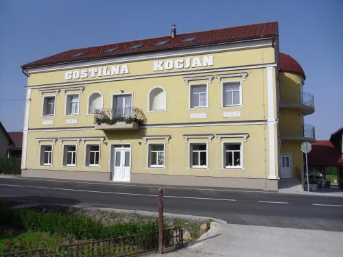 a yellow building on the side of a street at Gostilna in prenočišče KOCJAN in Bizeljsko