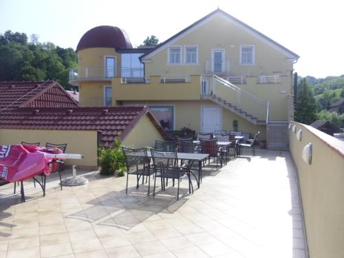 a patio with tables and chairs in front of a building at Gostilna in prenočišče KOCJAN in Bizeljsko