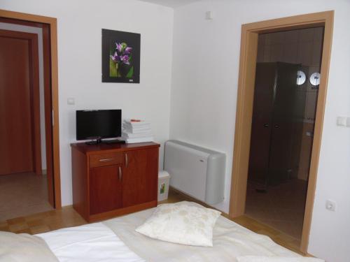 a bedroom with a bed and a tv and a mirror at Gostilna in prenočišče KOCJAN in Bizeljsko