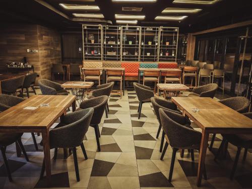une salle à manger avec des tables et des chaises en bois dans l'établissement Hotel City Code, à Zenica