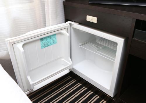 an empty refrigerator with its door open in a kitchen at APA Hotel Sakai Ekimae in Sakai